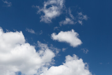 Naklejka na ściany i meble white fluffy clouds on blue sunny sky