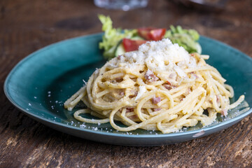 spaghetti carbonara on a green plate