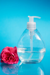 soap bottle with rose on blue background
