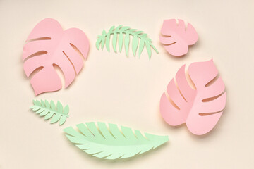 Frame made of paper tropical leaves on beige background