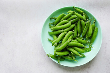 Green peas on the plate top view. Legume vegetables. Fresh crop 