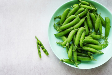 Green peas on the plate top view. Legume vegetables. Fresh crop 