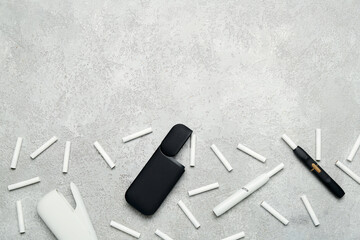 Composition with modern electronic cigars and sticks on grey background