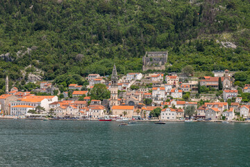 Fototapeta na wymiar Landscape Exposure done from a cruise ship, showing the sea entrance to Kotor bay and its beautiful coastal landscapes and small villages , on a sunshiny day.