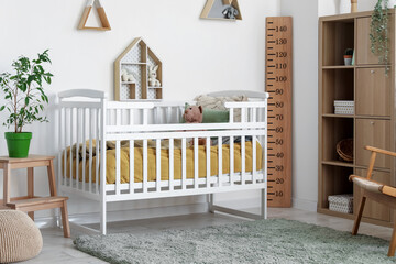 Interior of children's bedroom with crib, shelves and toys