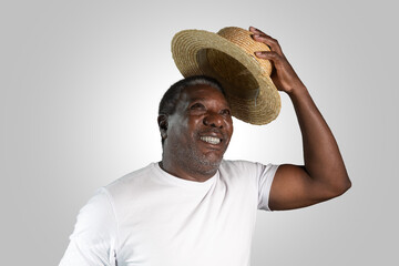 portrait of senior black man holding a samba hat. Looking at the camera smiling.