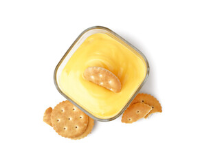 Bowl of tasty cheddar cheese sauce with crackers on white background