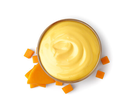 Bowl of tasty cheddar sauce with cheese slices on white background