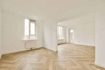 an empty room with wood floors and white walls, there is a large window in the wall to the right