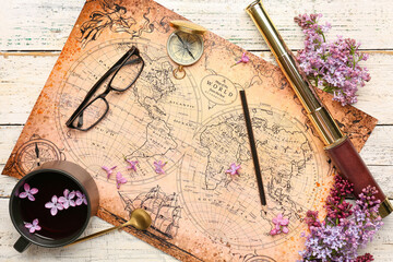 World map with spyglass and lilac twigs on white wooden table