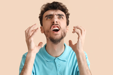 Stressed young man on beige  background