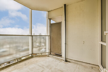 an empty balcony with blue sky and white clouds in the background, taken from inside one of the apartment's windows