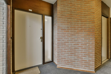 an empty room with brick walls and wood trims on the wall, there is a door leading to another room