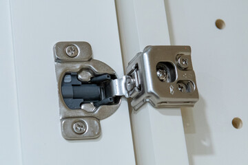 polished stainless door hinge on a cabinet door for interior design