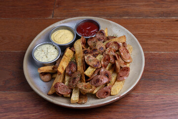 Salchipapa, peruana, con aderezos de barbacoa, mostaza y mayonesa casera