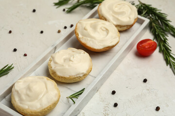 Plate of tasty croutons with cream cheese on light background