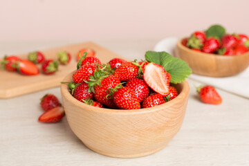 Fresh strawberries in bowl on wooden table