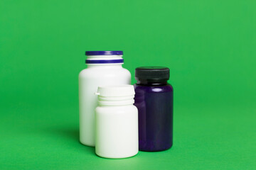 Plastic bottles for vitamins on color background