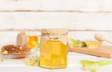 Linden honey with leaves and flowers on table