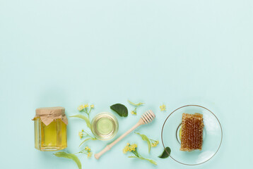 Linden honey with leaves and flowers on color backgroung, top view