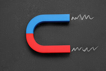 Horseshoe shaped magnet on grunge black background