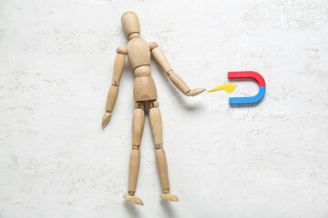 Wooden mannequin with magnet on white background