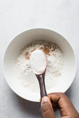 A tablespoon of white sugar, granulated sugar in an antique measuring spoon