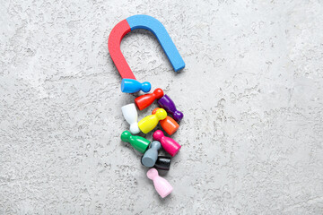 Magnet attracting group of customers on grunge grey background. Marketing concept