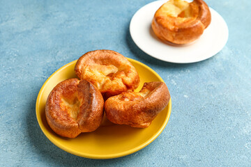 Plate with tasty Yorkshire pudding on blue background