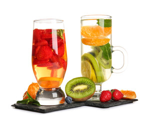 Glasses of infused water with different sliced fruits on white background