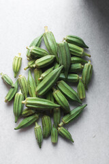 Top view of okra on a white background, lady fingers on a marble countertop, okro being prepared for cooking