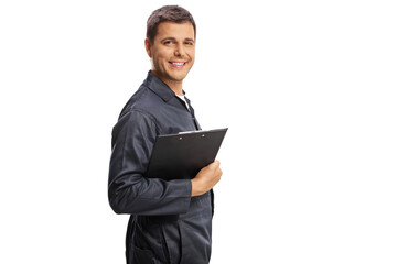 Auto mechanic holding a clipboard and smiling at camera