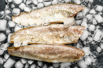 Raw codfish with ice cubes on dark background