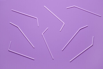 Lilac plastic straws on purple background