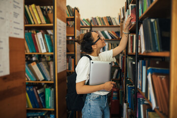 A student stuying and reading books in a public library.