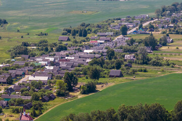 Fototapeta na wymiar panoramic aerial view of eco village with wooden houses, gravel road, gardens and orchards