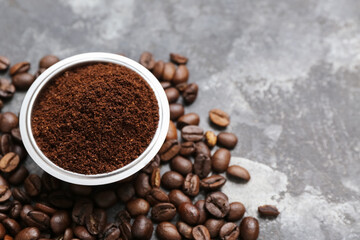 Bowl with coffee powder and beans on grunge background