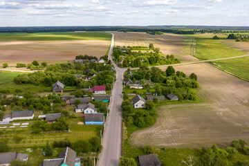 panoramic aerial view of eco village with wooden houses, gravel road, gardens and orchards