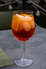 Orange color cocktail, ice cubes and slices of orange fruit.