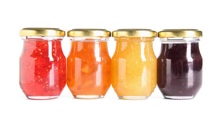 Jars of different jams on white background