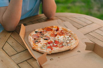 Delicious pizza in a box. Summer street cafe. Natural. Italian pizza with tomatoes, cheese and...
