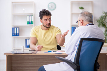 Obraz premium Young male patient visiting old male doctor