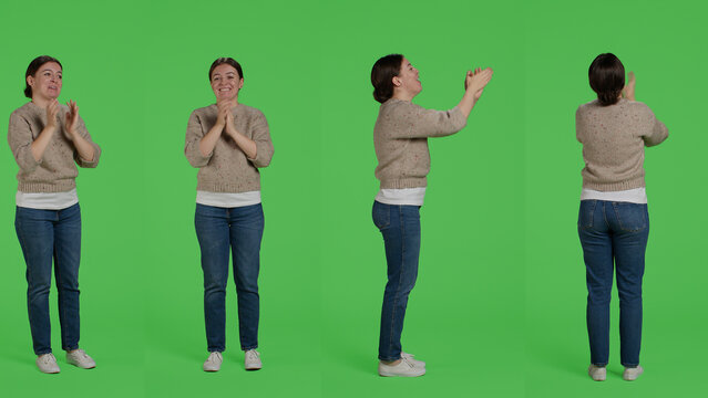 Cheerful woman saying congratulations and applauding in studio, doing standing ovation gesture and clapping hands. Young happy person celebrating success and supporting, greenscreen backdrop.