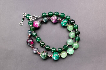 Statement green and pink stone bead necklace on black, unique handmade jewelry background, massive unusual jewelry, promotional photo for an online jewellery store