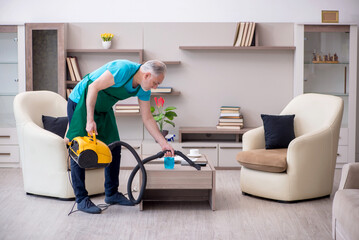 Old male contractor cleaning the house