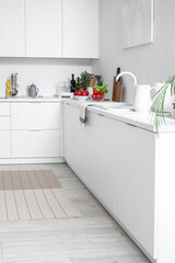 White countertop with sink and vegetables in modern kitchen