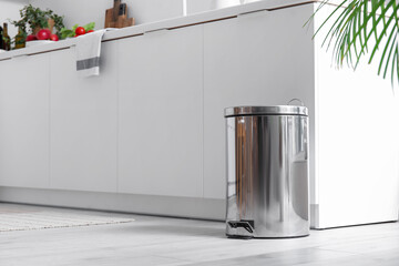 Metallic trash bin in interior of modern kitchen
