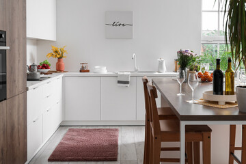 Interior of light kitchen with stylish island table