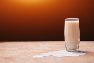 fresh milk splash and glass on wooden background