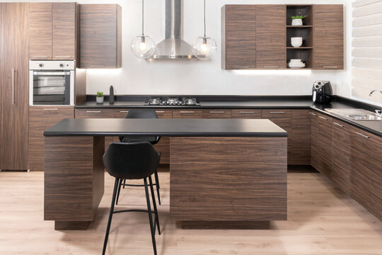 A modern wooden kitchen with a clean, organized counter and a fully stocked refrigerator, ready to be used for cooking